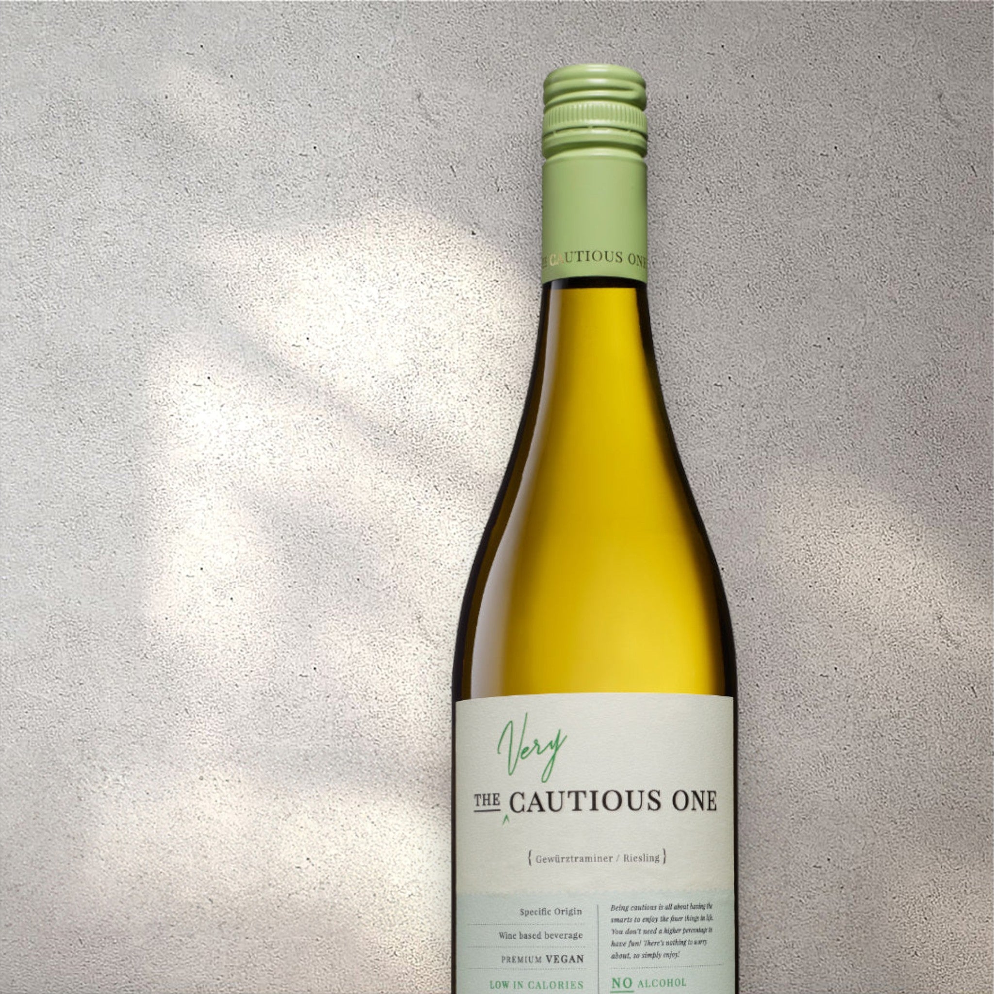 Closeup of a De Bortoli The Very Cautious Riesling alcohol-free white wine bottle with a detailed label, set against a textured concrete wall, highlighting its refined design and pale yellow colour.